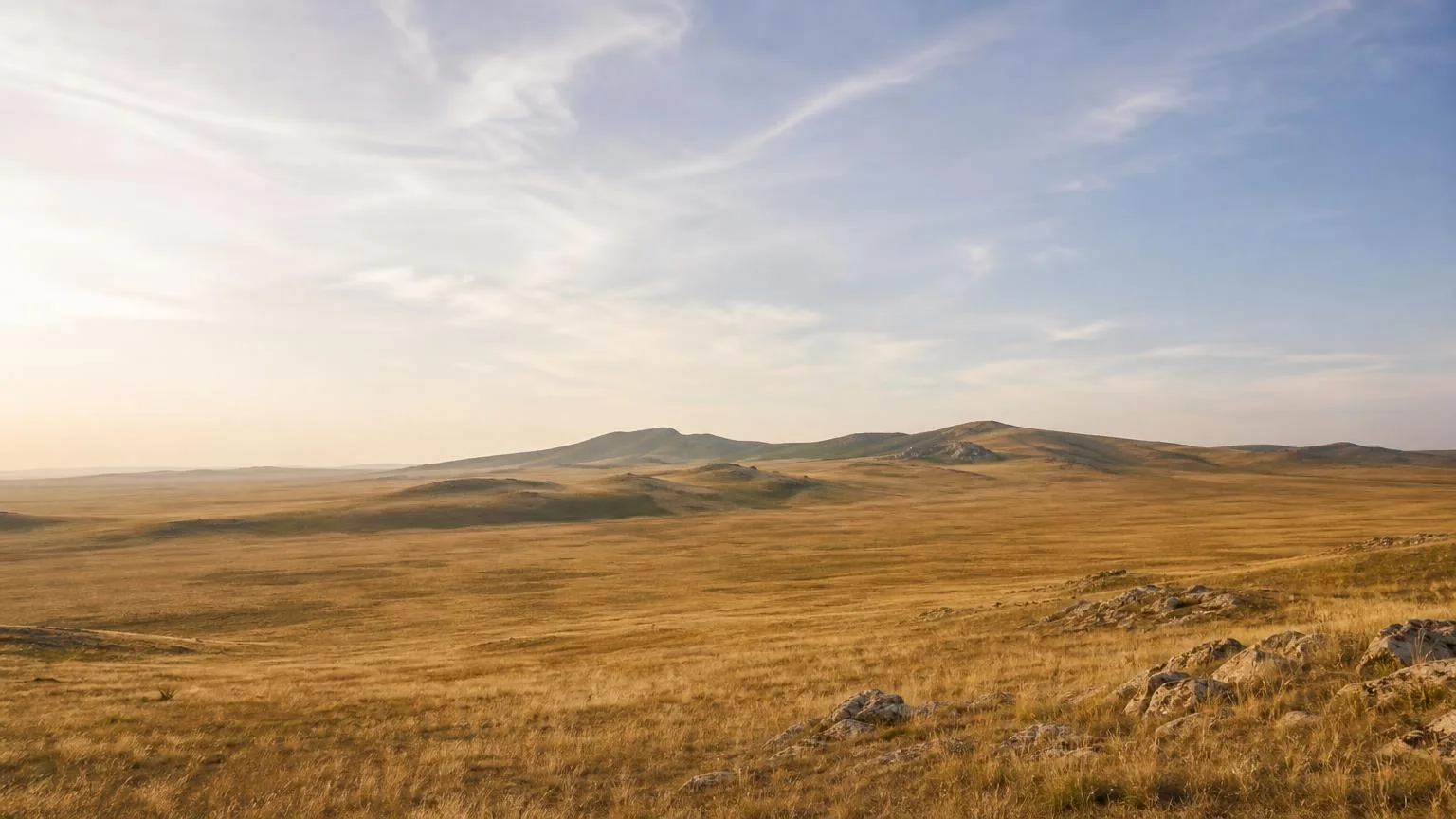 Wide open steppe landscape under a soft bright sky
