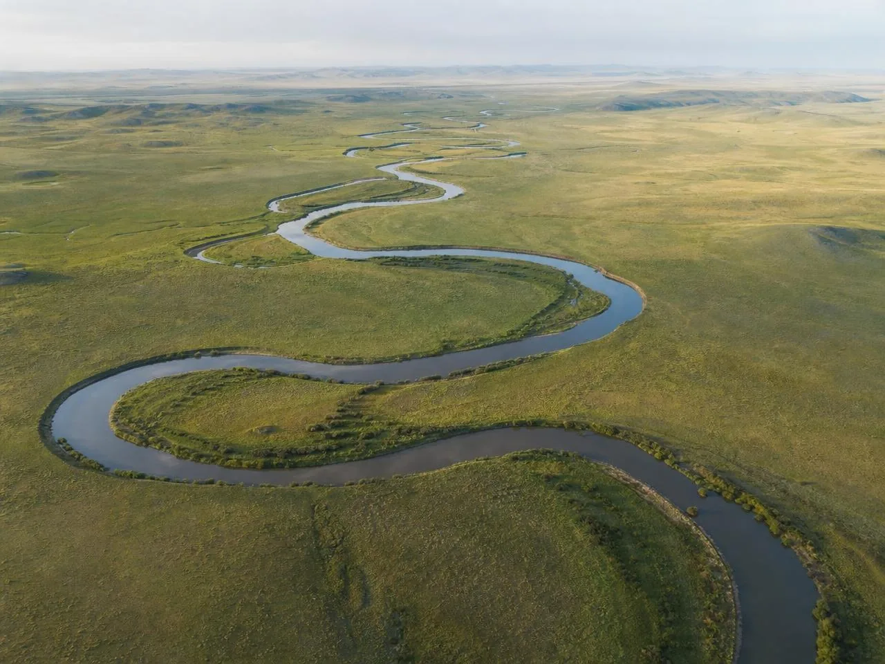 Aerial view of a river winding through steppe grassland